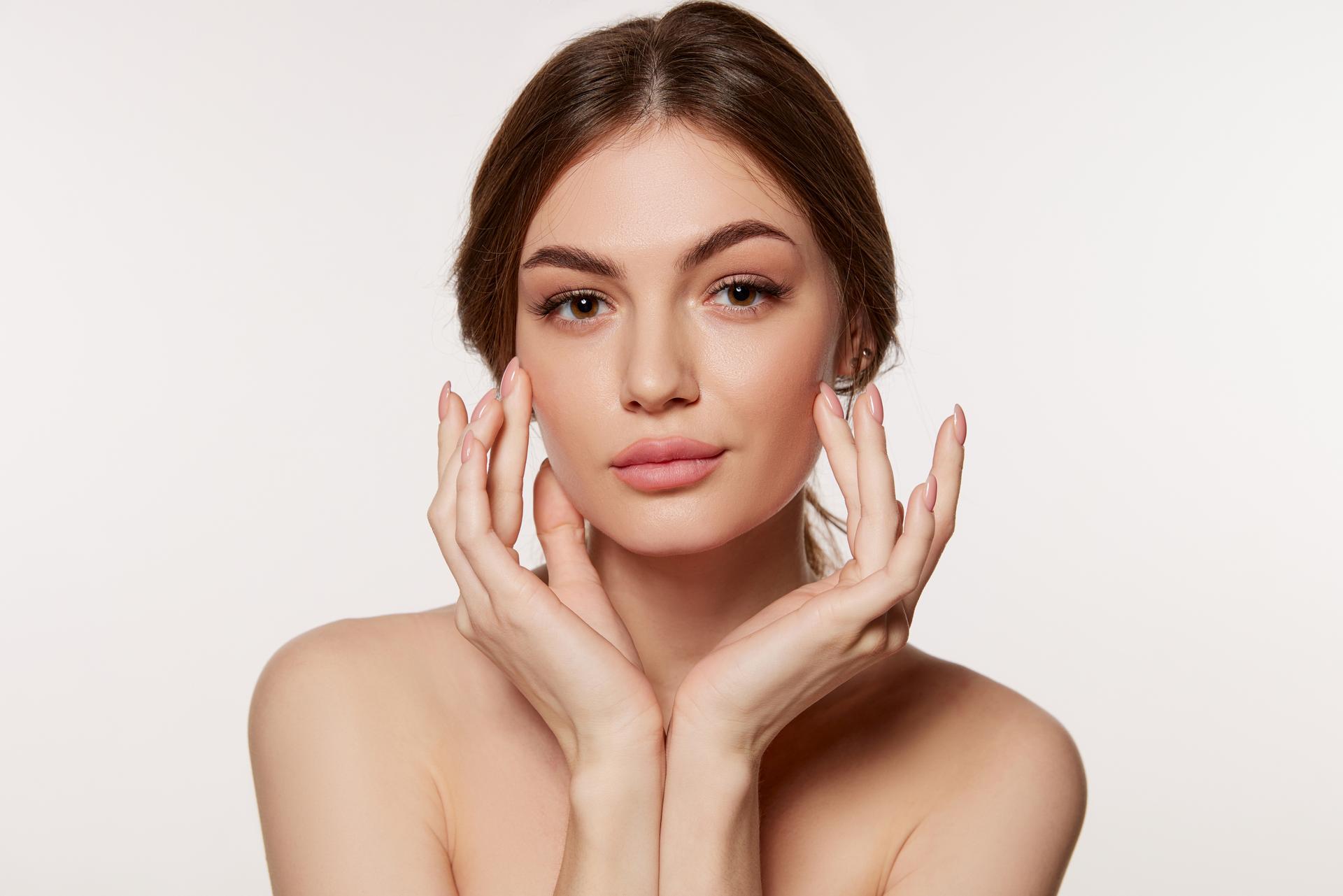 Portrait of young beautiful woman with perfect smooth skin isolated over white background. Perfect face, taking care after skin condition