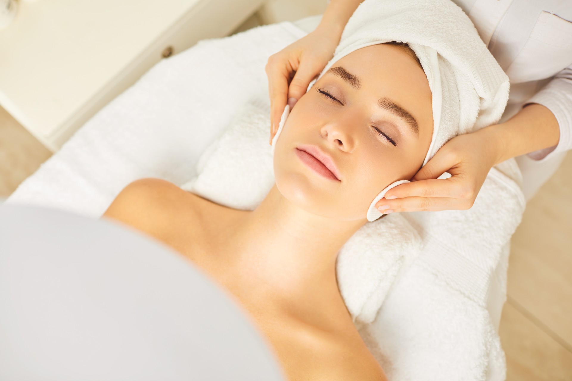 Beautician makes cleansing facial skin girl.